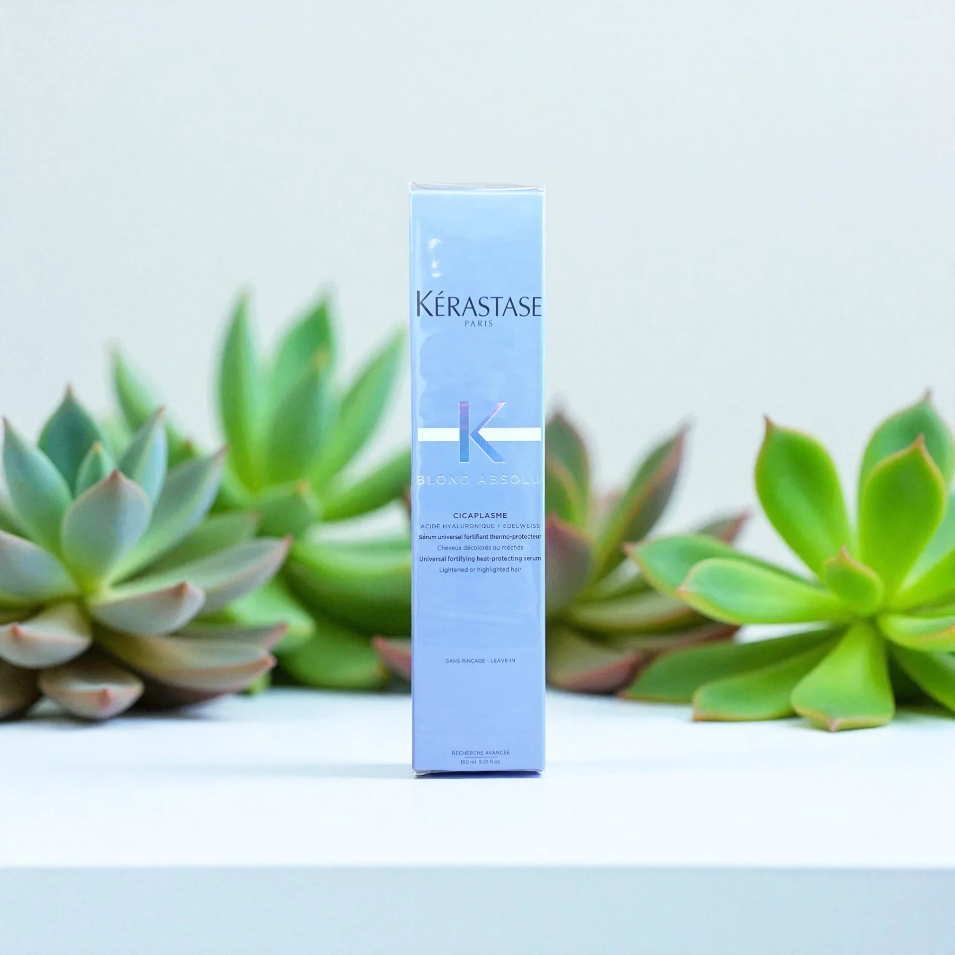 Kérastase Blond Absolu Cicaplasme serum box with succulents in the background.