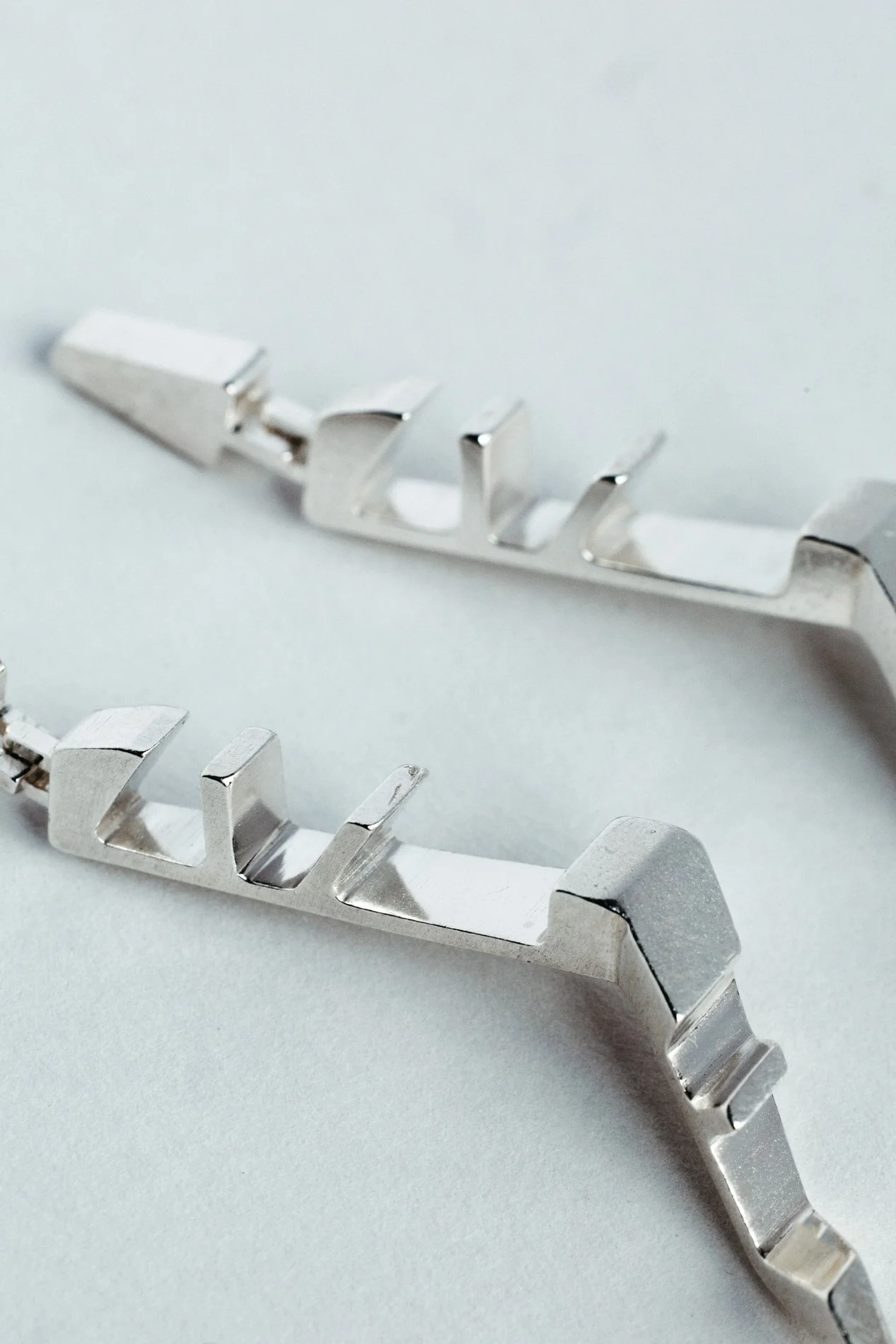 Engrenages earrings V2.2 by Sajfrt — long sprocket-inspired form in silver or gold, handcrafted in Belgium with rotational geometry and presence.