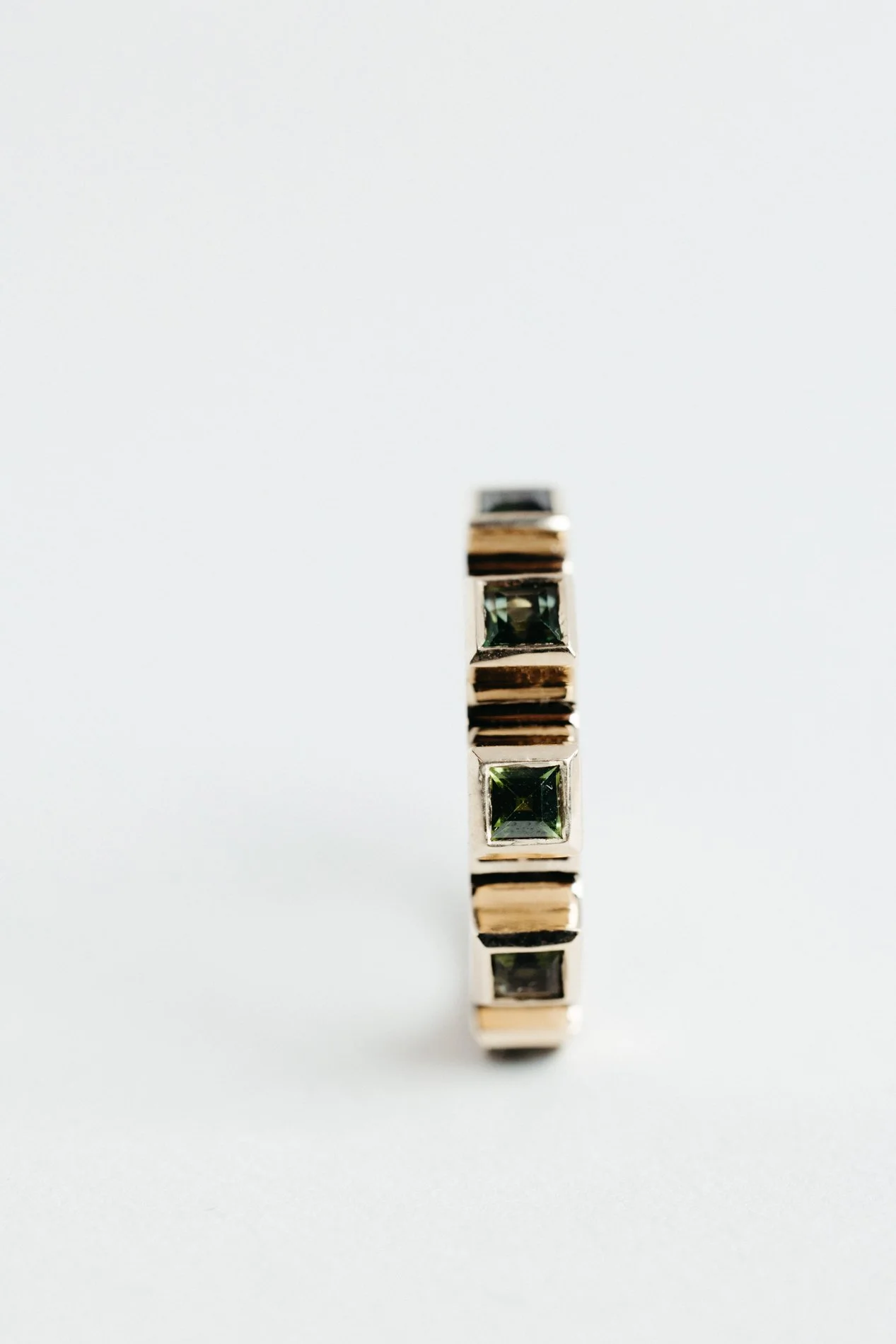 Engrenages ring V4.4 by Sajfrt — sprocket-form ring in silver or gold, set with green tourmalines or topazes. Handcrafted in Belgium with rhythm.