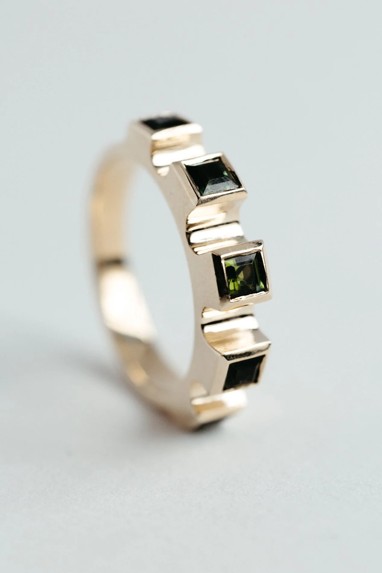 Engrenages ring V4.4 by Sajfrt — sprocket-form ring in silver or gold, set with green tourmalines or topazes. Handcrafted in Belgium with rhythm.