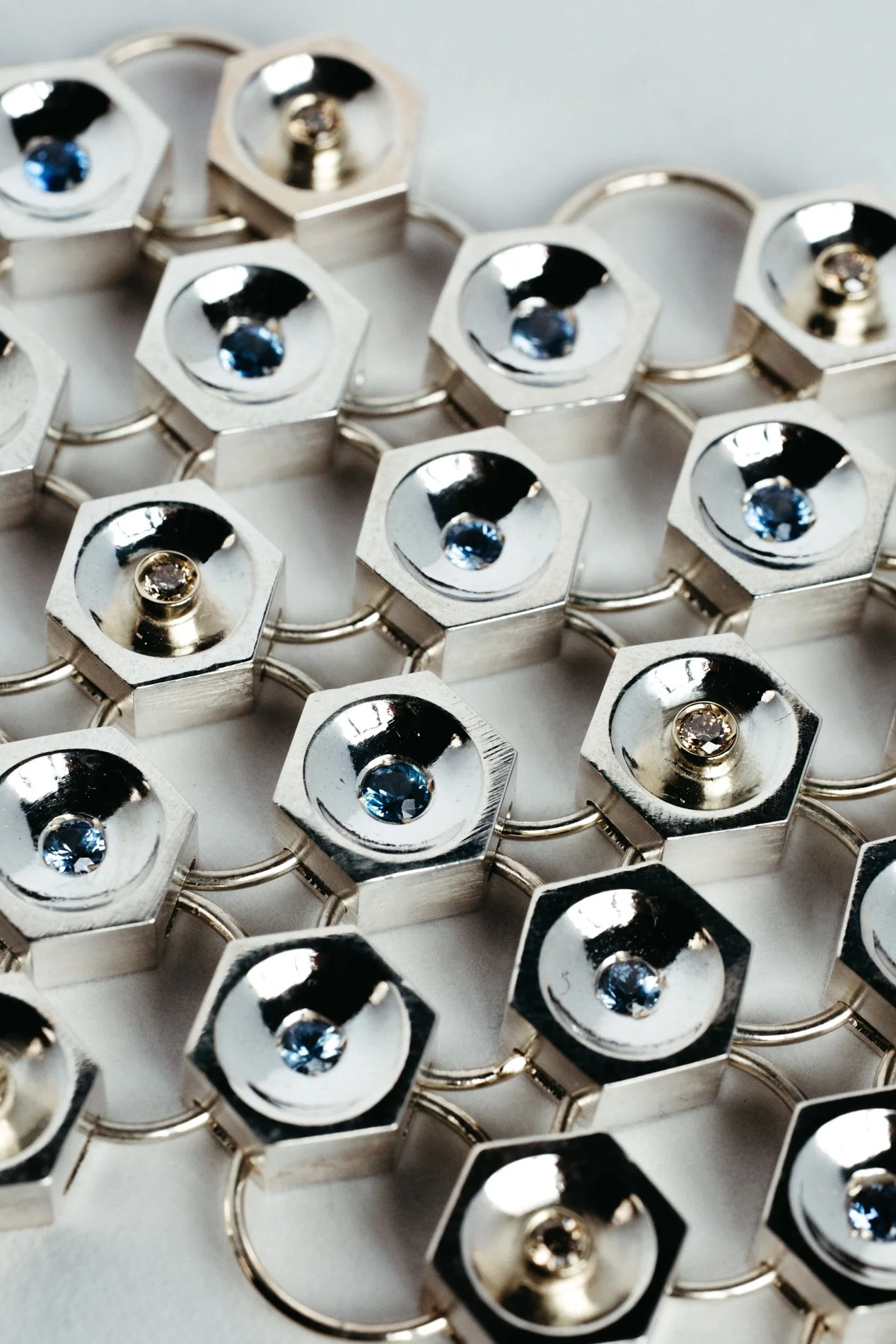 Silver and gold bracelet V1.1 from the Particles family — hexagonal forms with sapphires and salt & pepper diamonds, handcrafted by Sajfrt in Brussels.