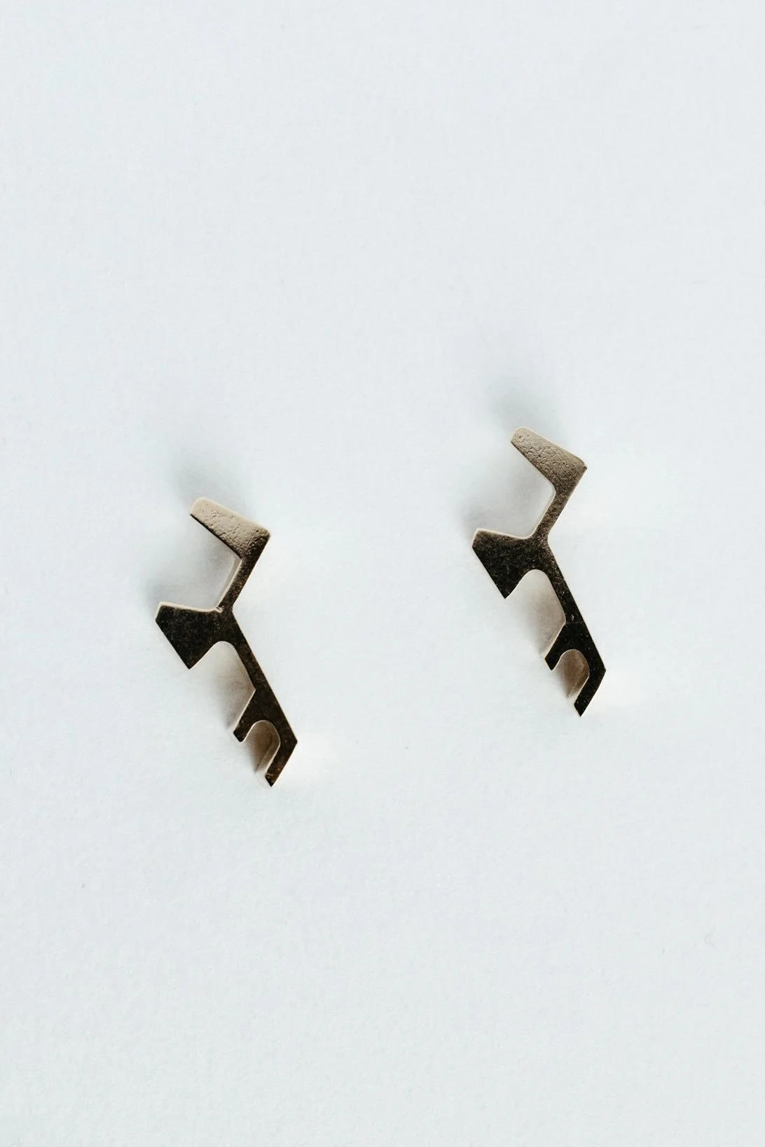 Engrenages studs V2.3 by Sajfrt — compact sprocket-inspired earrings in silver or gold, handcrafted in Belgium with mechanical refinement.