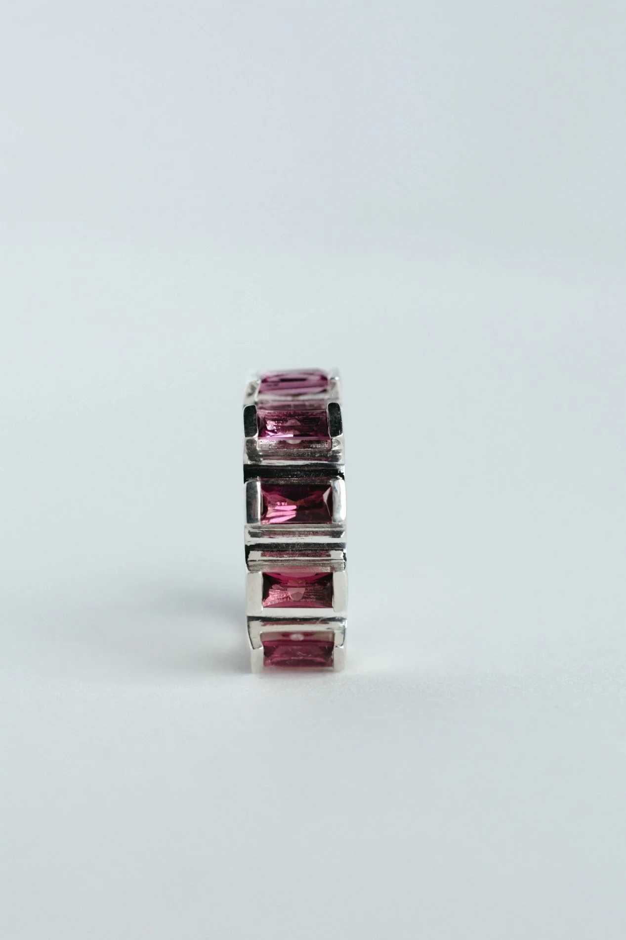 Engrenages ring V4.3 by Sajfrt — silver or gold sprocket-form ring with green or pink tourmalines. Handcrafted in Belgium with precise movement.