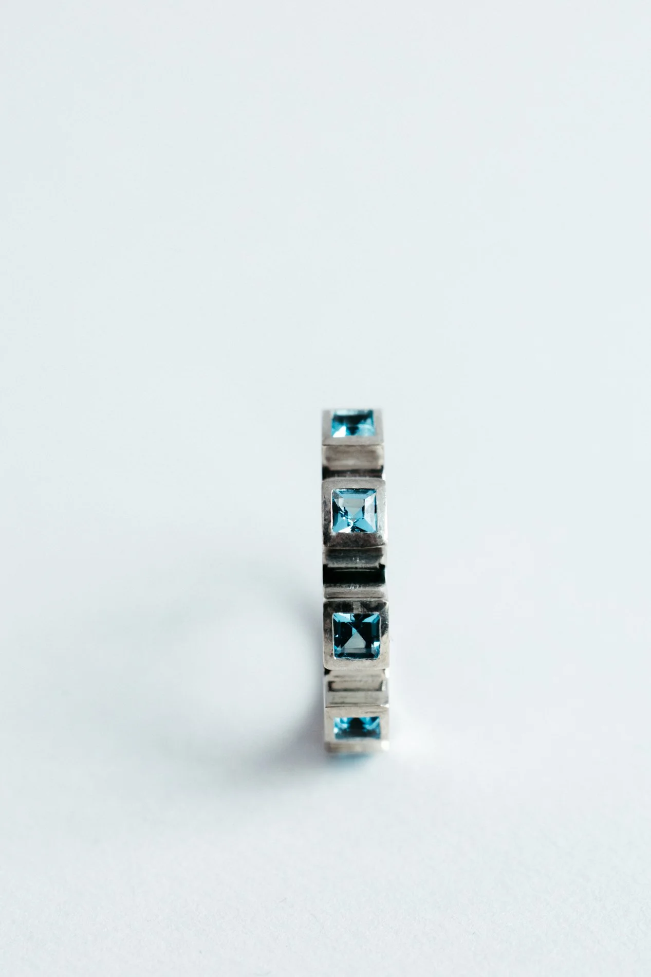 Engrenages ring V4.4 by Sajfrt — sprocket-form ring in silver or gold, set with green tourmalines or topazes. Handcrafted in Belgium with rhythm.