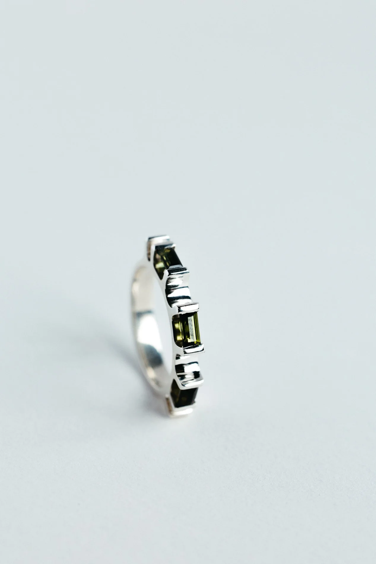 Engrenages ring V4.2 by Sajfrt — sprocket-inspired form in silver or gold with green tourmaline. Handcrafted in Belgium, designed with intention.