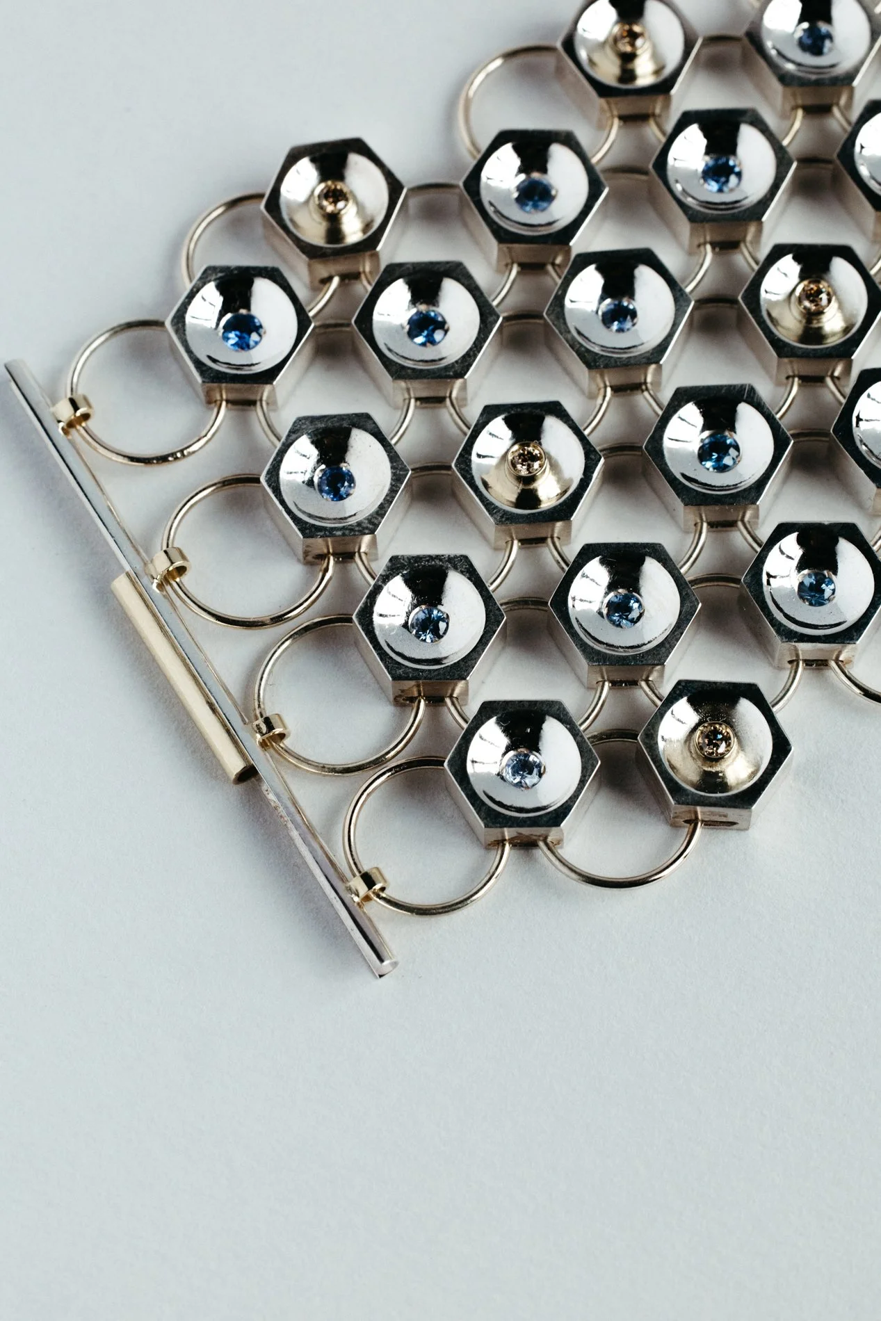Silver and gold bracelet V1.1 from the Particles family — hexagonal forms with sapphires and salt & pepper diamonds, handcrafted by Sajfrt in Brussels.