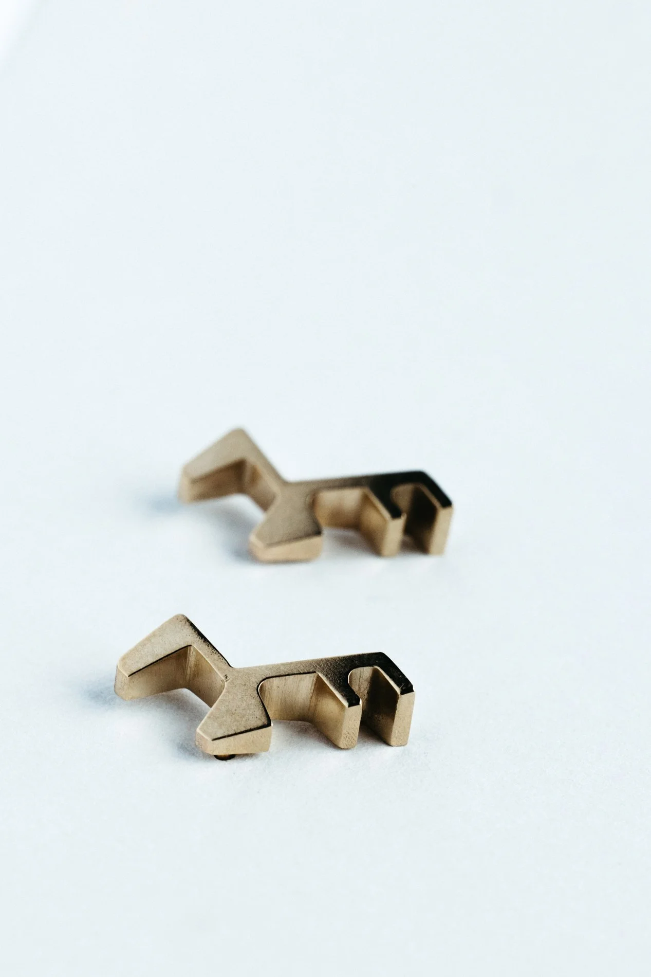 Engrenages studs V2.3 by Sajfrt — compact sprocket-inspired earrings in silver or gold, handcrafted in Belgium with mechanical refinement.