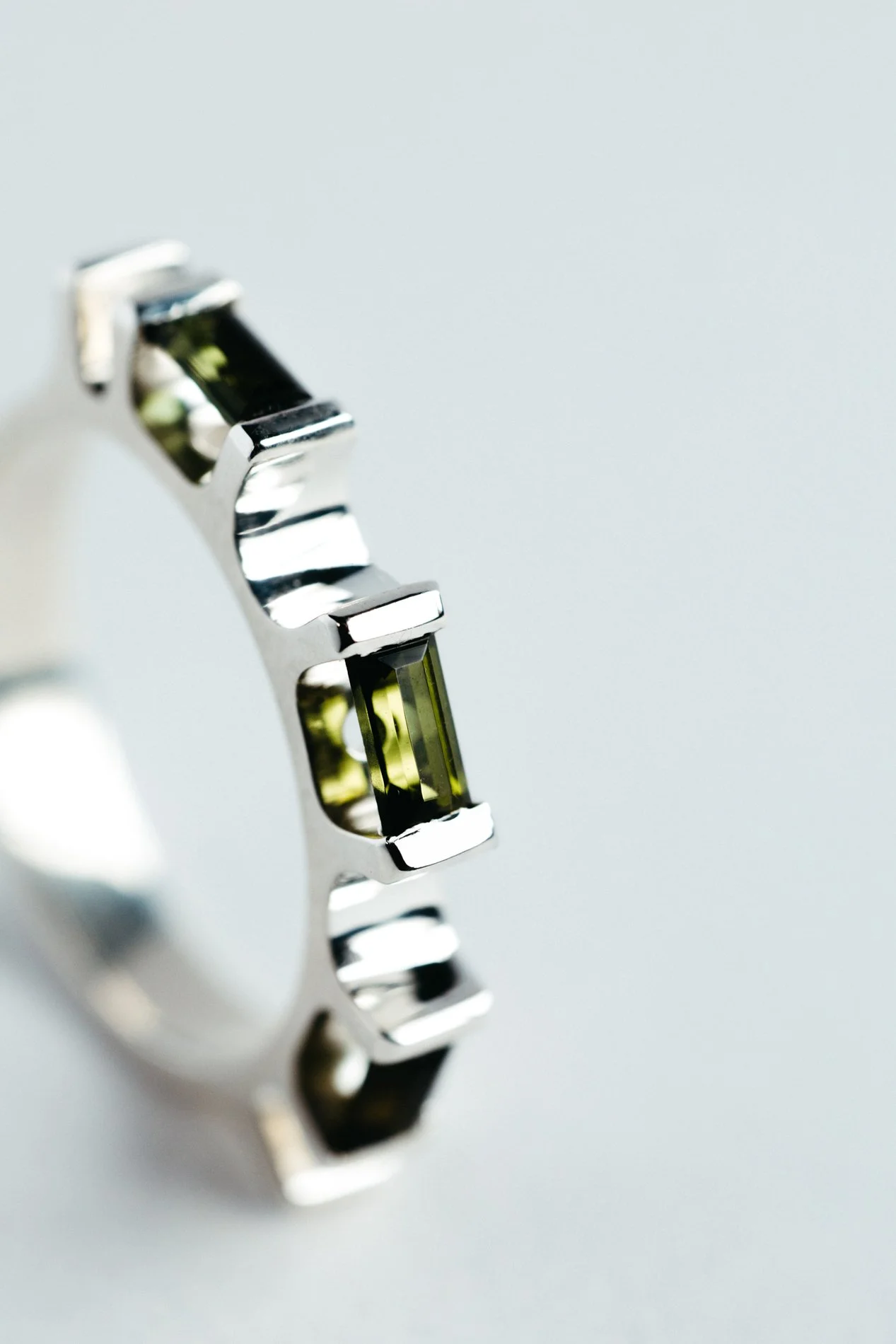 Engrenages ring V4.2 by Sajfrt — sprocket-inspired form in silver or gold with green tourmaline. Handcrafted in Belgium, designed with intention.
