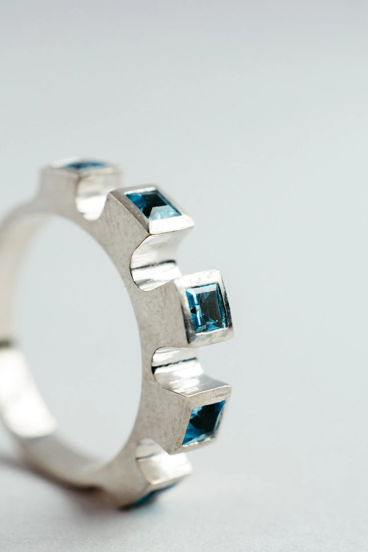 Engrenages ring V4.4 by Sajfrt — sprocket-form ring in silver or gold, set with green tourmalines or topazes. Handcrafted in Belgium with rhythm.