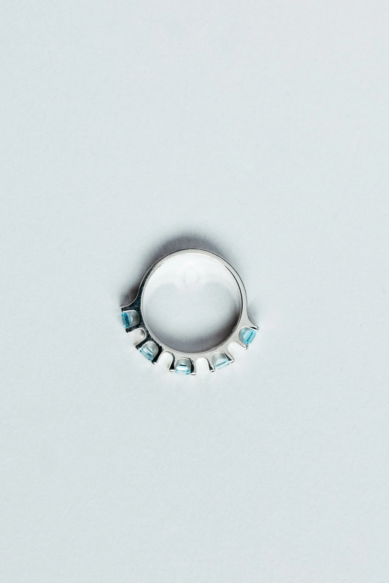 Engrenages ring V4.1 by Sajfrt — sprocket-inspired silver or gold ring with aquamarines or tourmalines. Handcrafted in Belgium with quiet geometry.