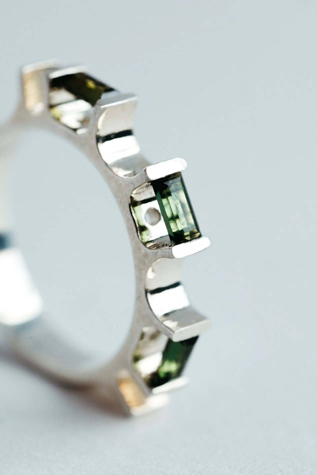 Engrenages ring V4.2 by Sajfrt — sprocket-inspired form in silver or gold with green tourmaline. Handcrafted in Belgium, designed with intention.