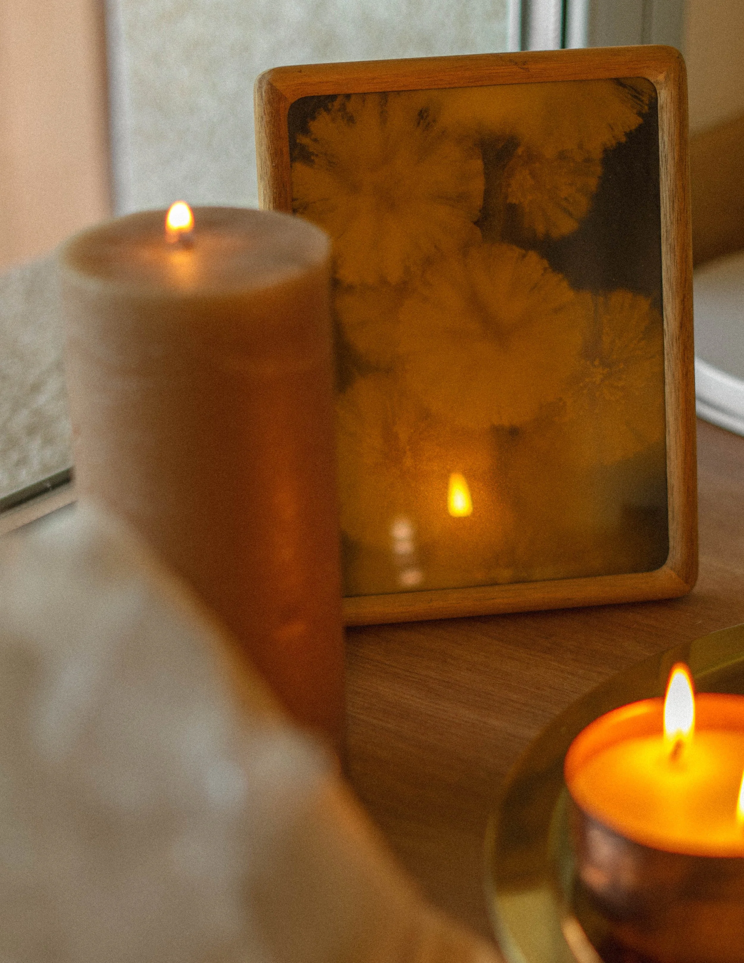 Configuración de altar con velas, flores, cristales y cartas, en un círculo en una alfombra beige.