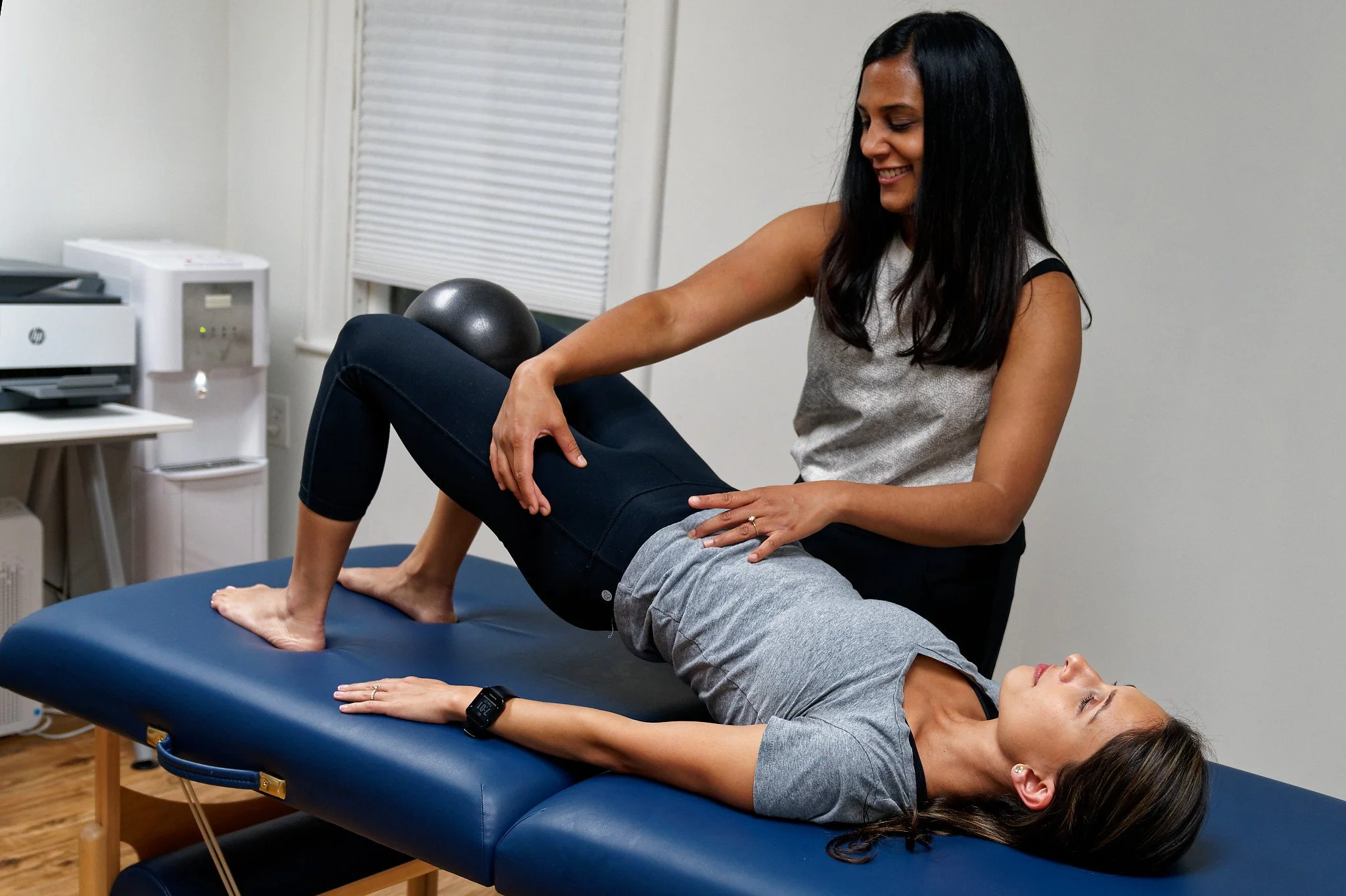 Physical therapist guiding someone on pilates 1:1