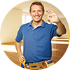 Smiling man wearing a blue shirt smiling and giving a thumbs up in a house setting