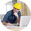 Young girl with a yellow construction helmet working on a laptop