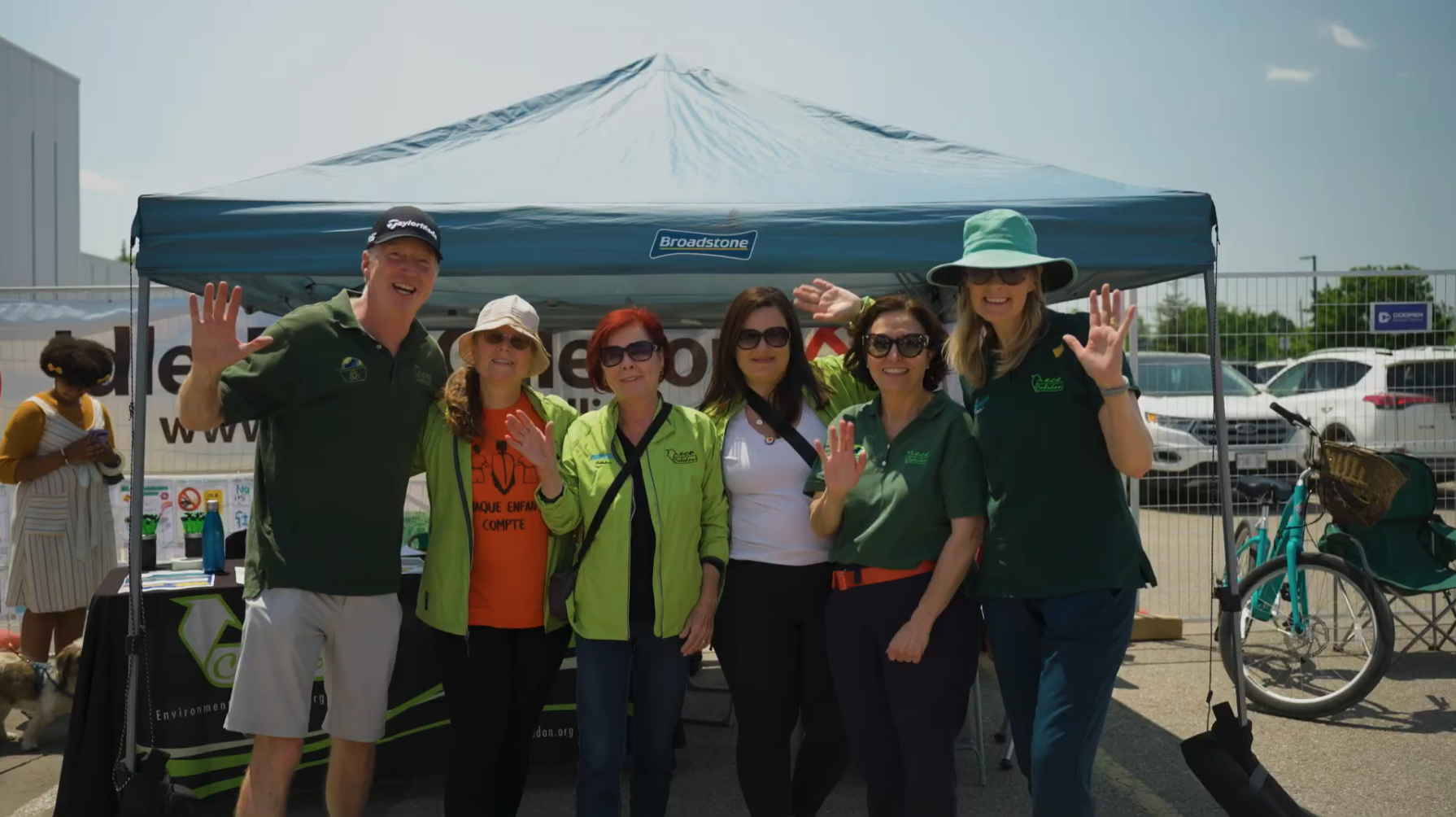 ecoCaledon team members smiling and waving together at an event