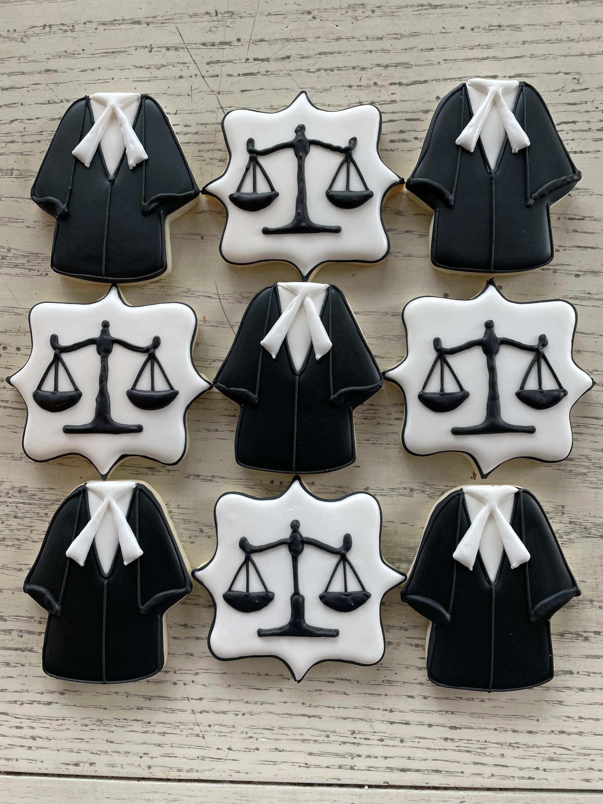 Cookies decorated as law-related symbols, including scales of justice and suits with ties.