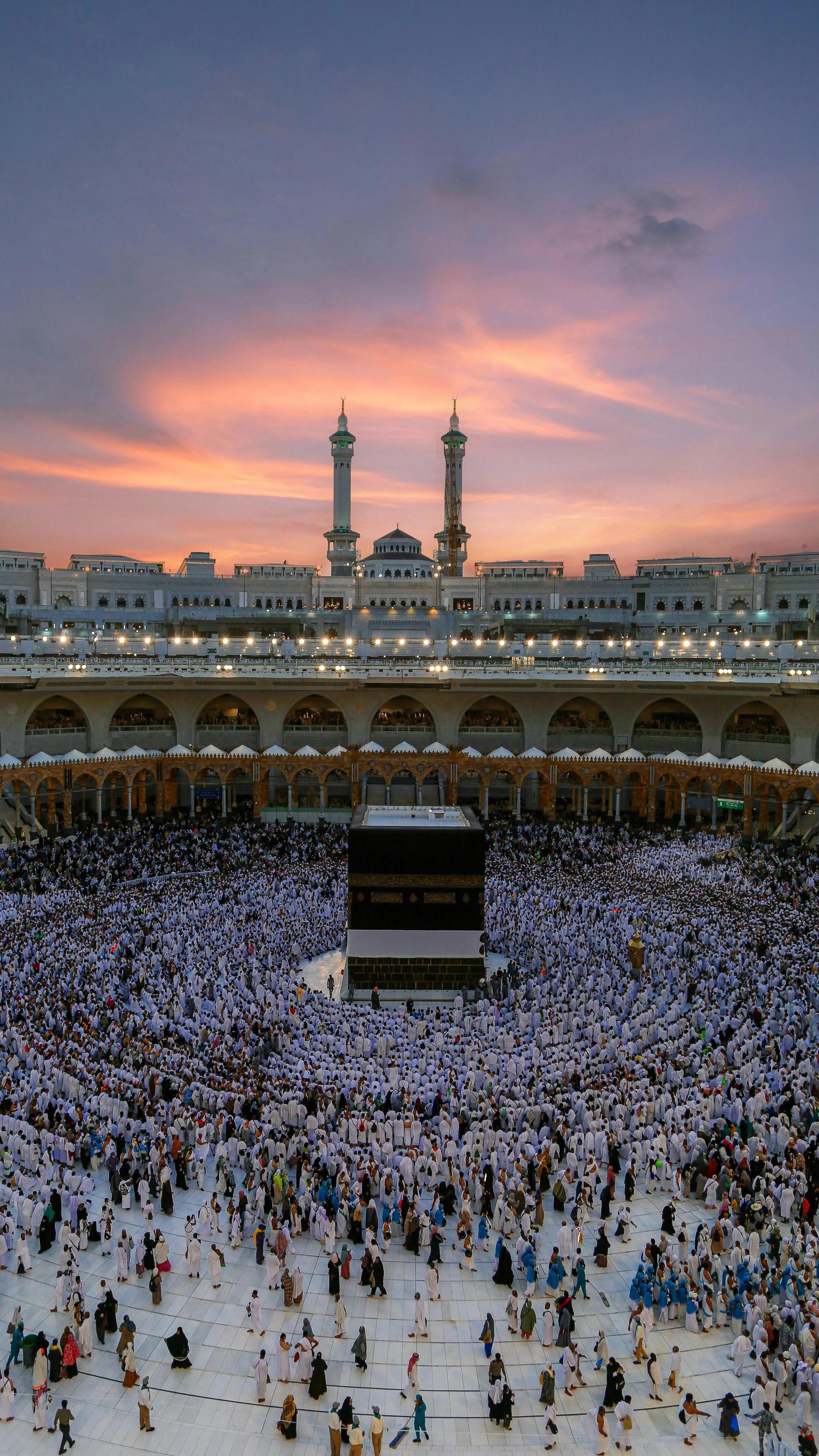 picture the kaaba at sunset with pilgrims around it and minaretes in the background