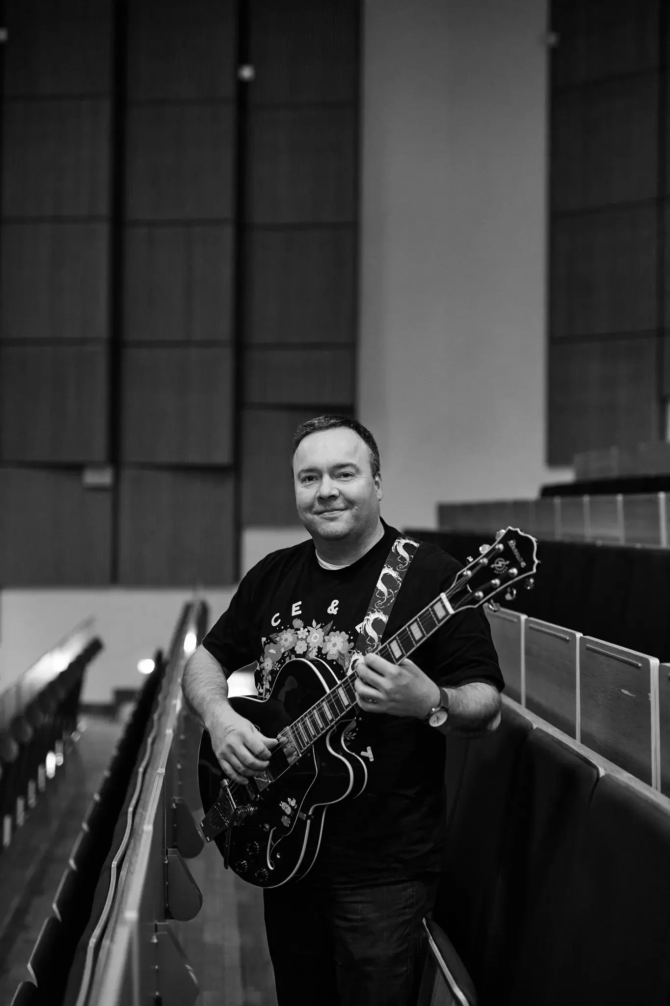Mann mit E-Gitarre im Konzertsaal, Schwarz-Weiß-Foto.