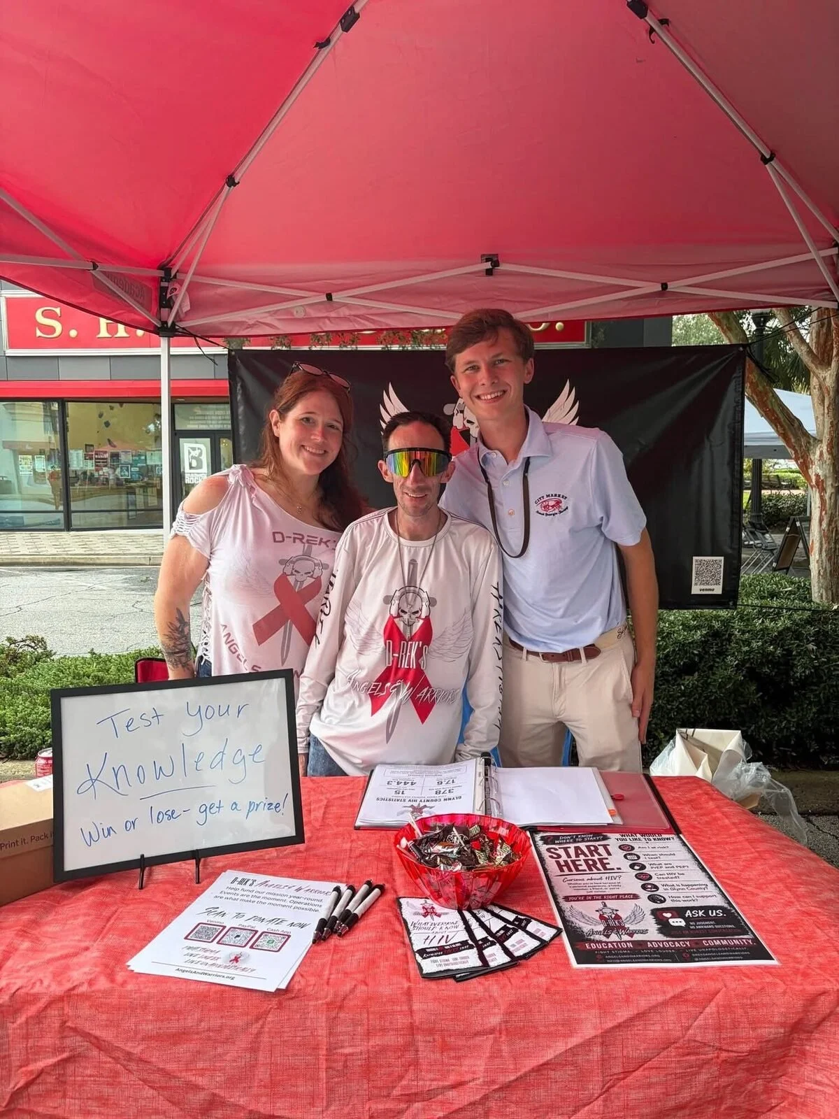 Angels & Warriors outreach table under a red tent at First Friday in downtown Brunswick