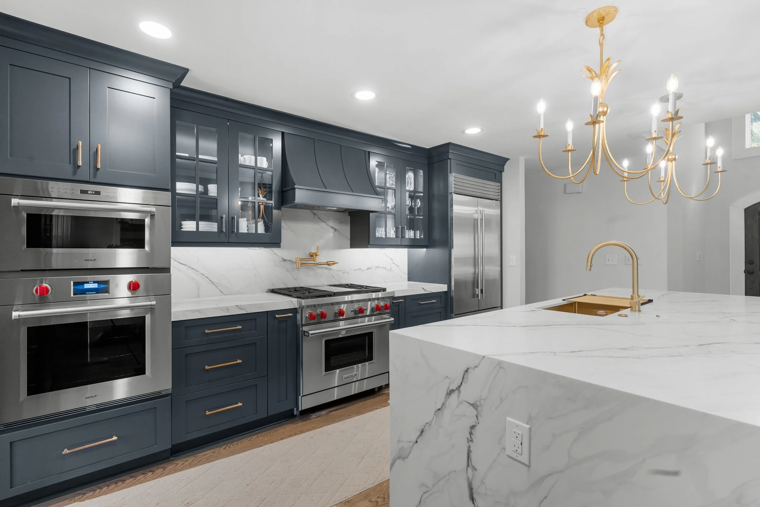 Luxury Kitchen with navy blue cabinets and gold accented cabinet hardware
