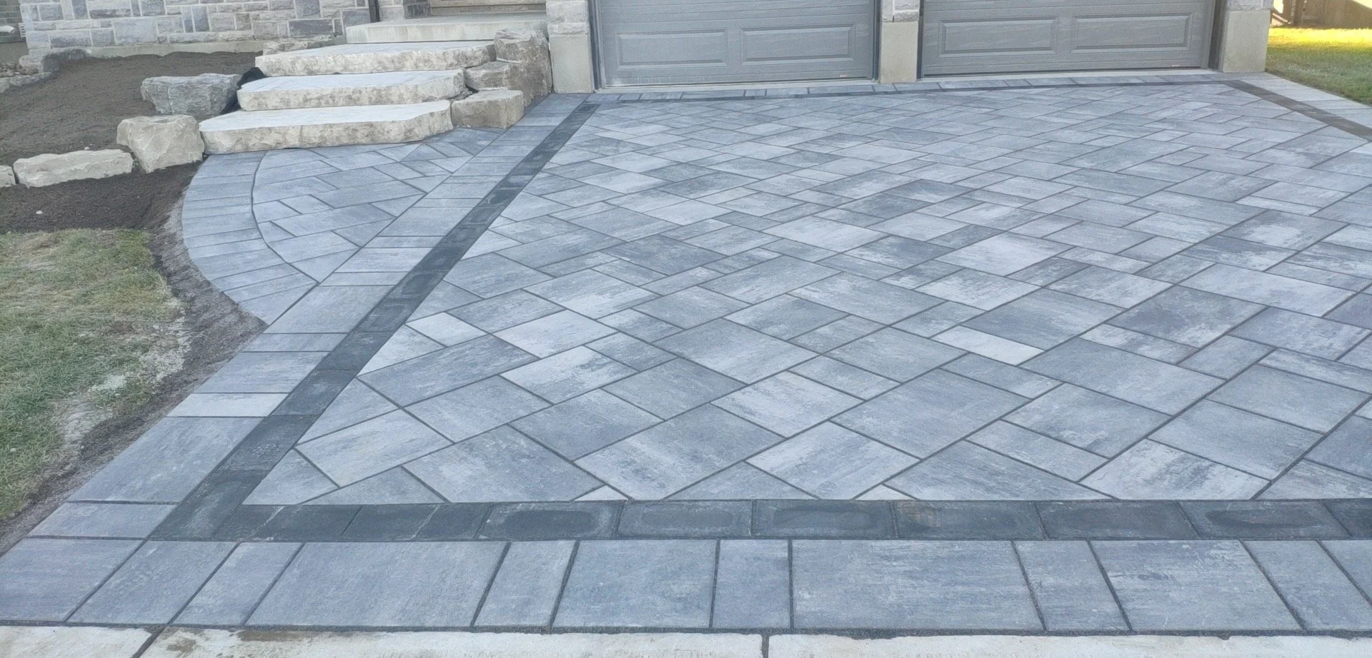 Paved driveway and walkway with gray concrete pavers