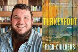 A man with short hair and a beard smiling, standing in front of a bookshelf in a library or bookstore. Next to him is the cover of a book titled 'Turneyfoot' by Rick Childers, featuring a colorful, textured background.