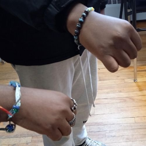 Close up of youth wrists with their friendships bracelets in colours of blue and black