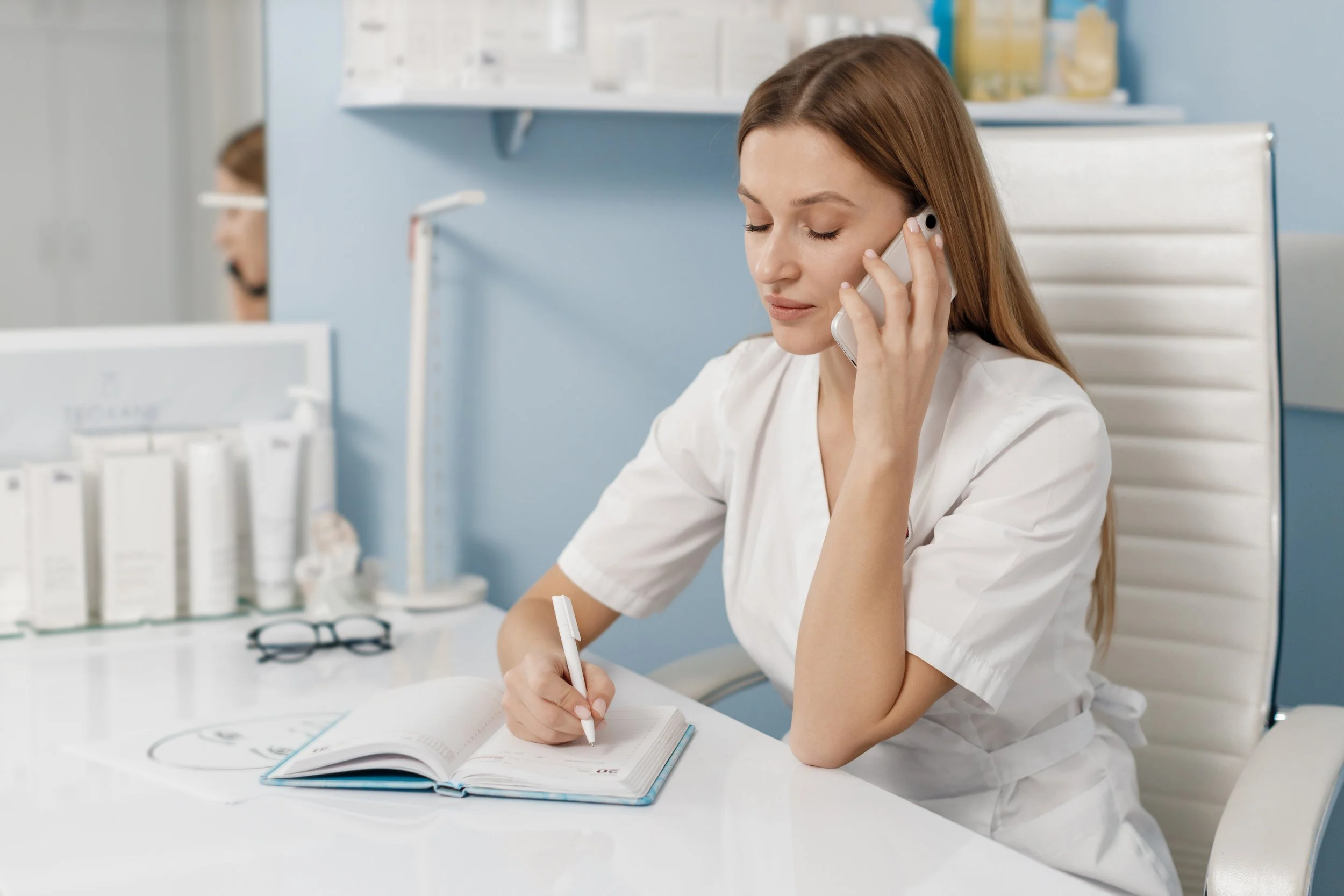 administrative assistant on phone in doctor's office