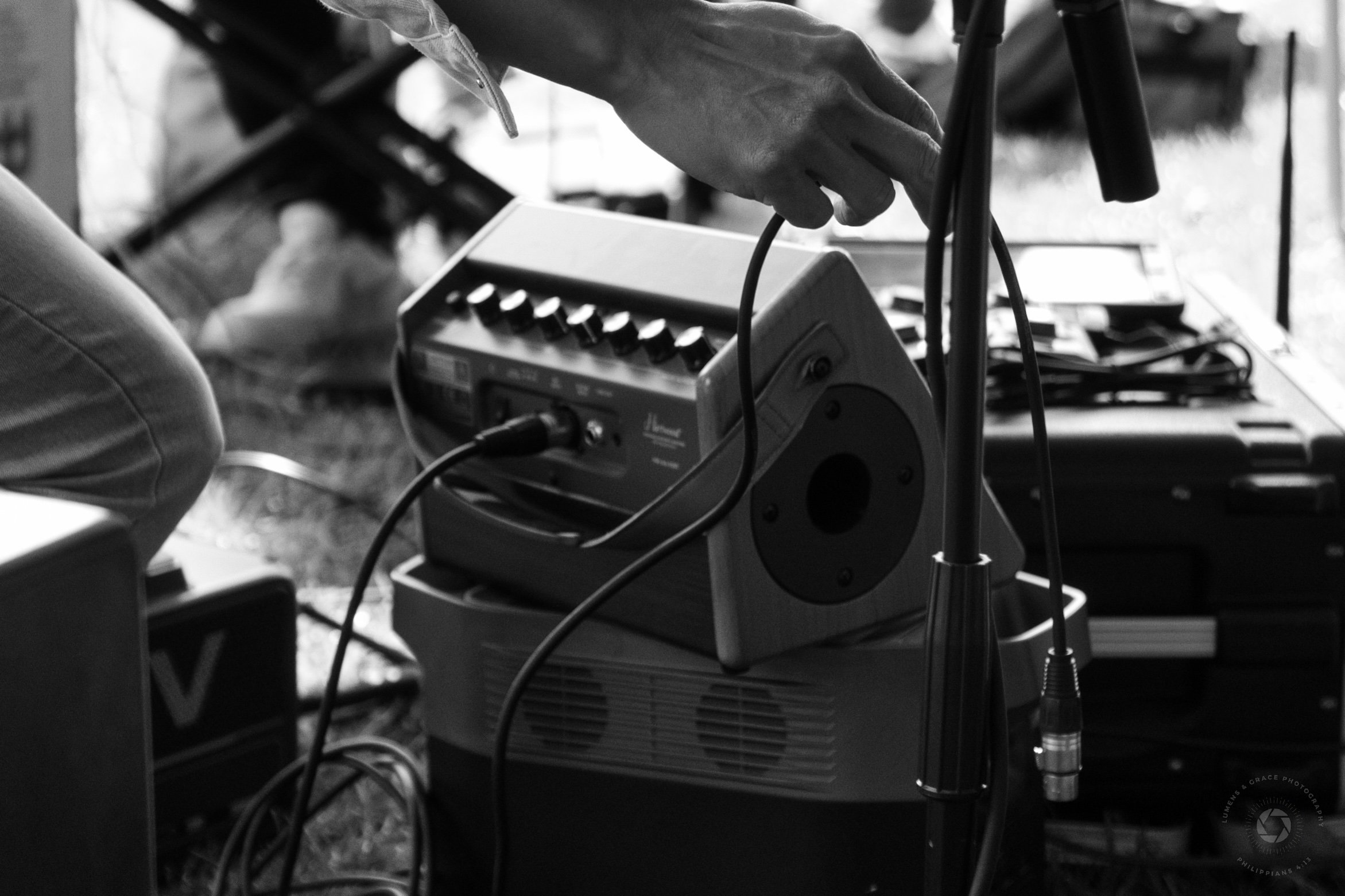 Person adjusting audio equipment cables outdoors