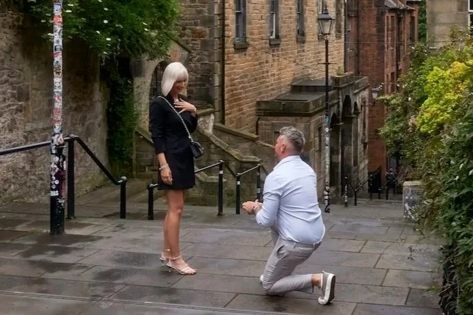 Man proposing to woman on city sidewalk