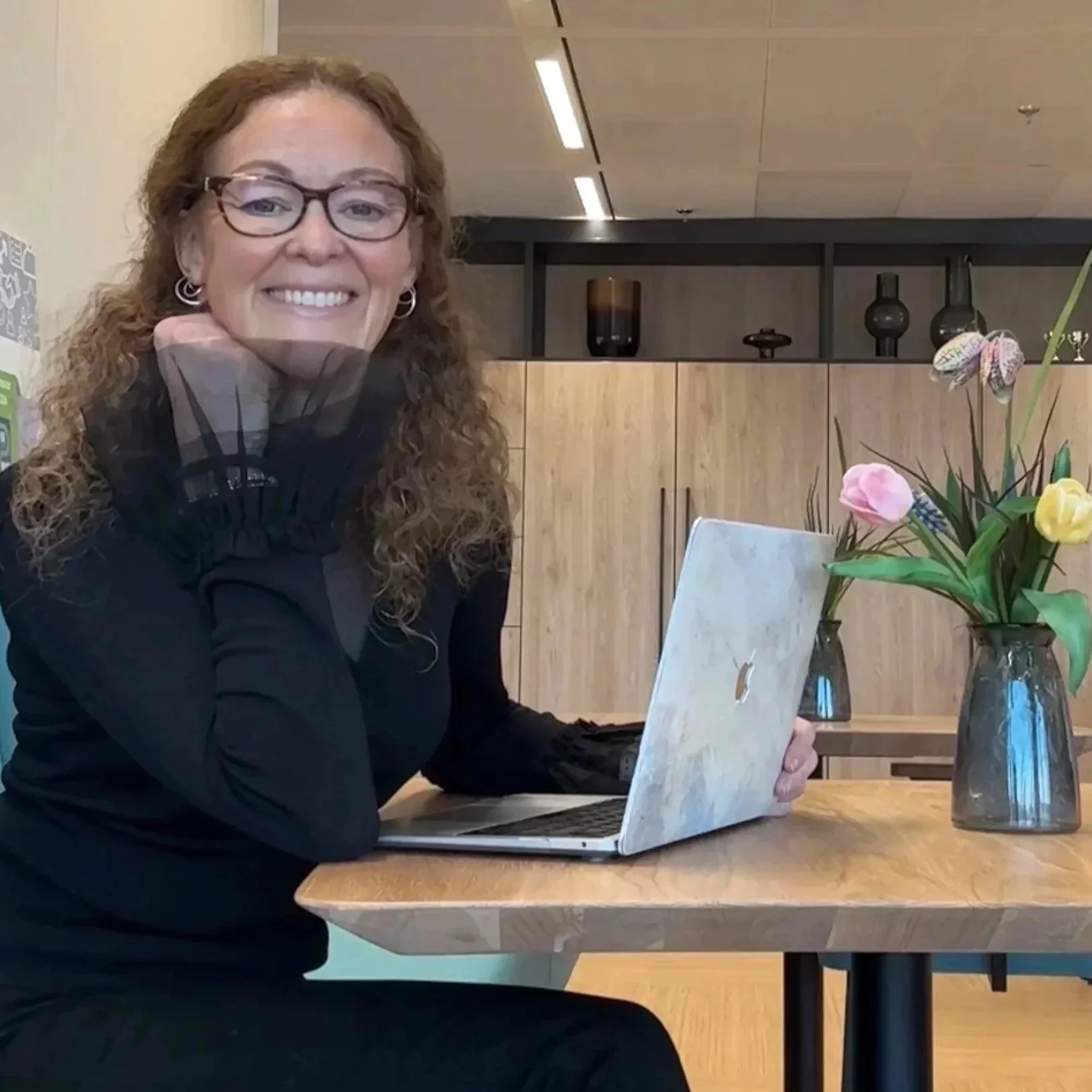 Lynda, seated at a desk