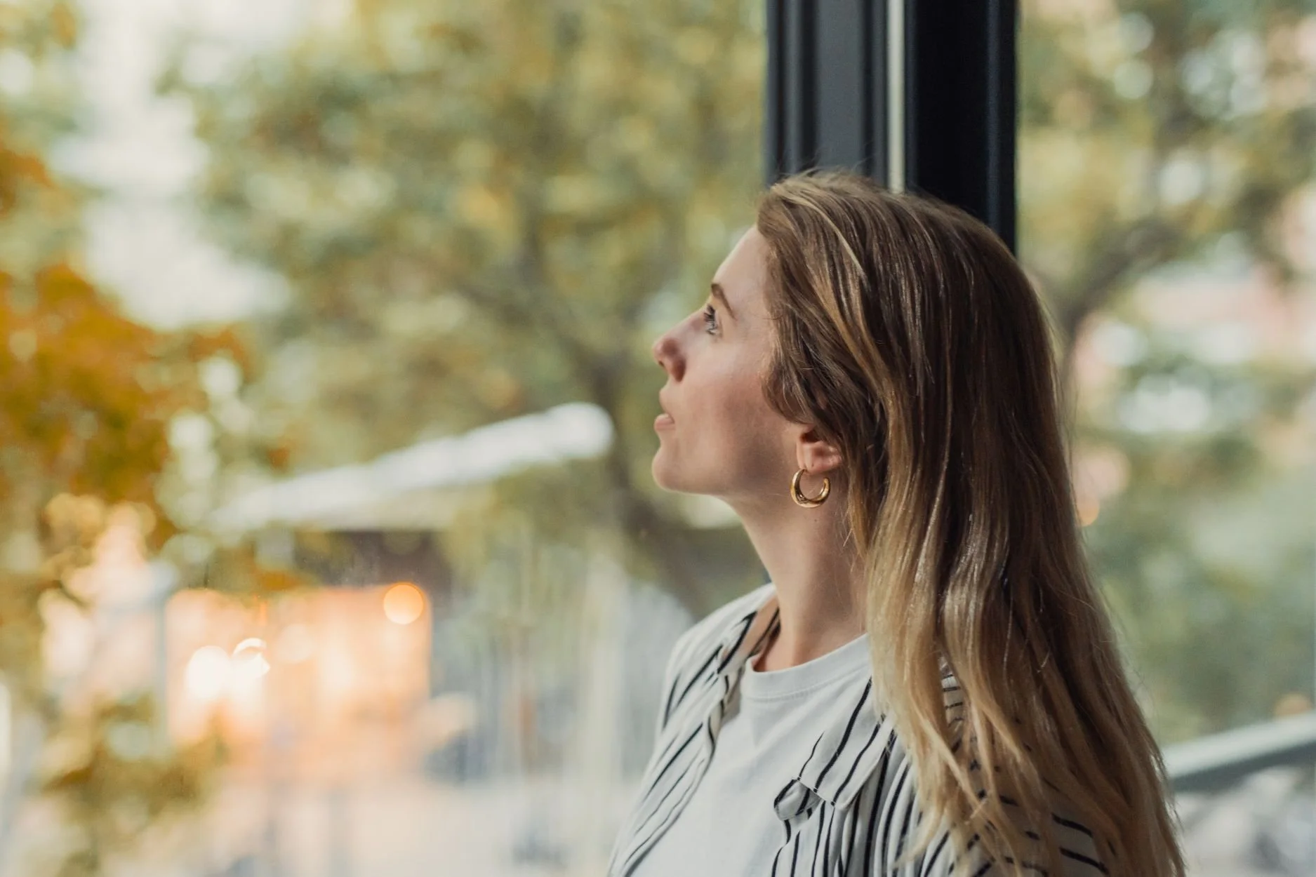 A woman looking out the window considering OCD Therapy in Toronto