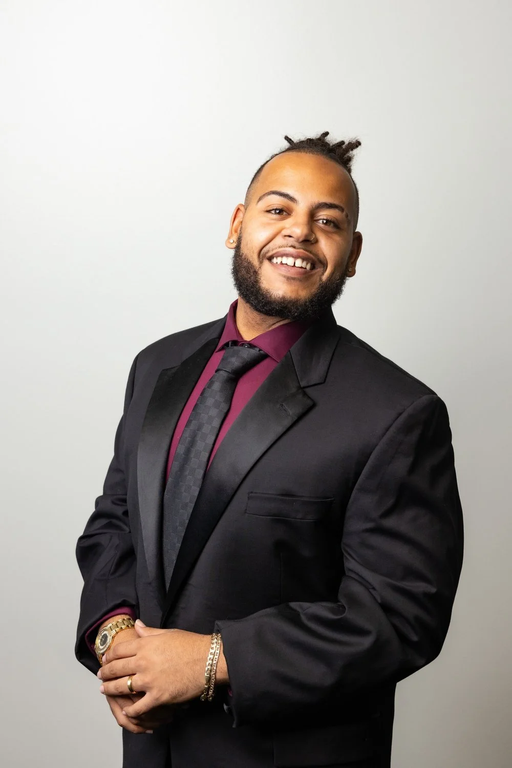 Darius Mills, licensed health insurance agent, smiling in a black suit and burgundy shirt