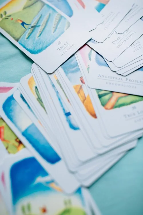 A spread of colorful tarot cards arranged on a light blue surface.