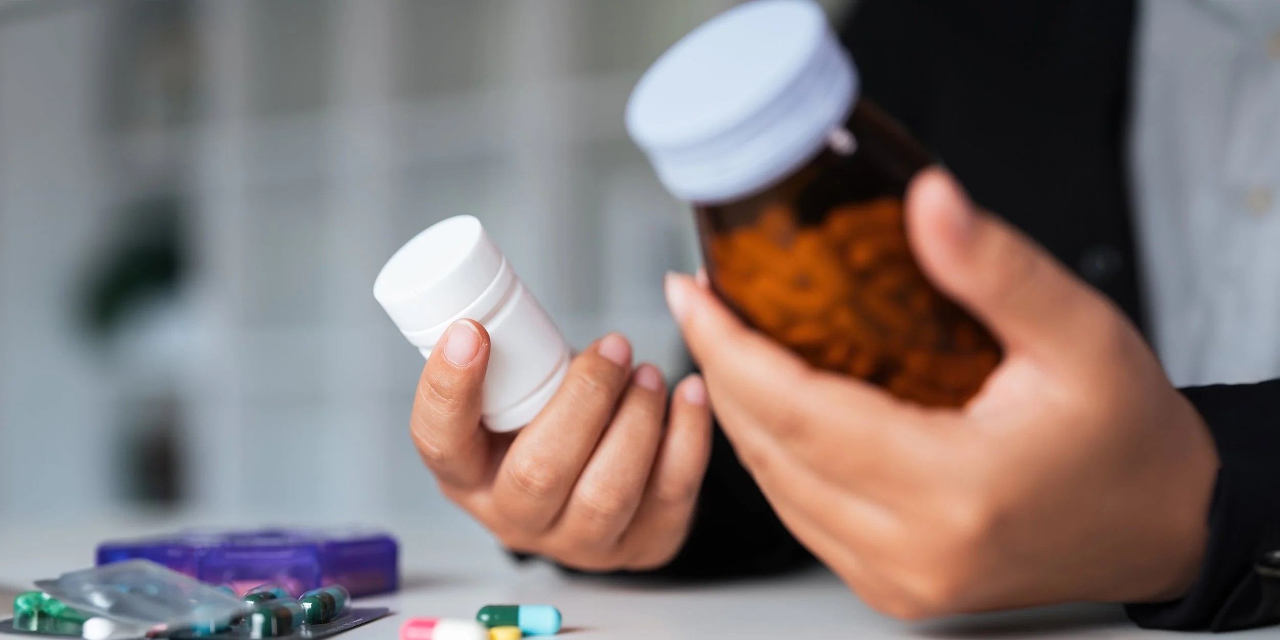 Woman hold bottle of drug tablet painkiller or vitamin supplement reading label ready to organizing medicine at home. medication healthcare concept