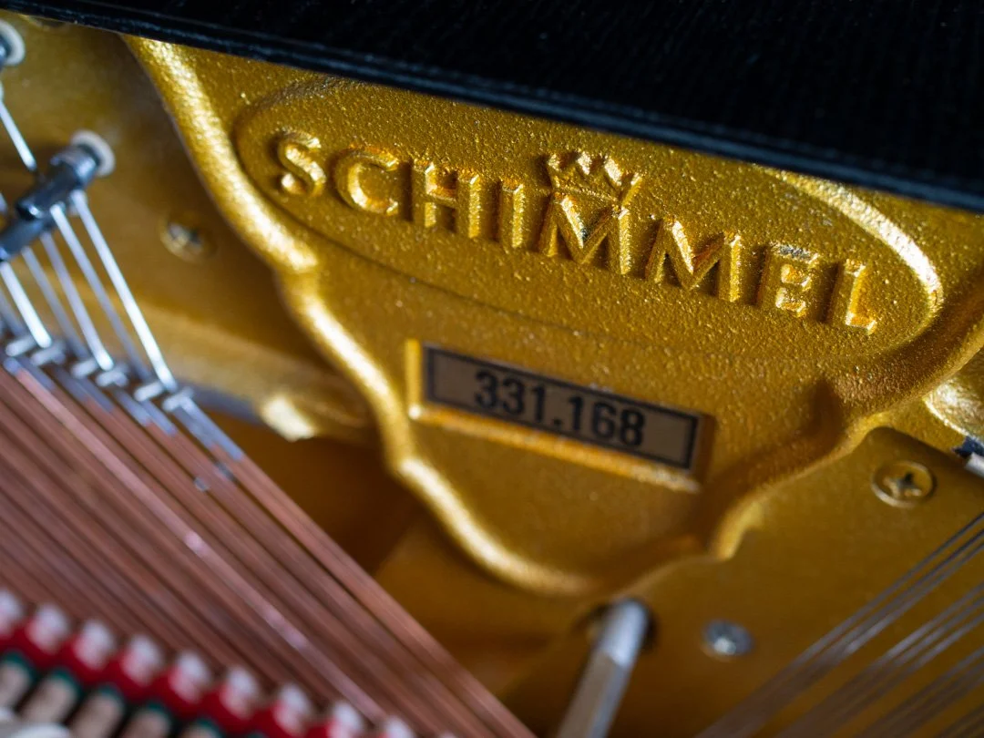 Inside a Schimmel upright piano showing the maker’s name