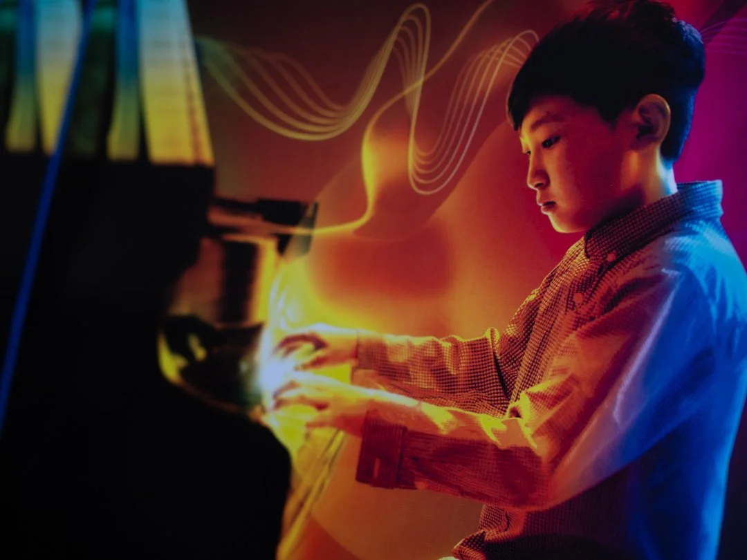 Close-up of ABRSM piano exam pieces book cover showing a young boy playing the piano