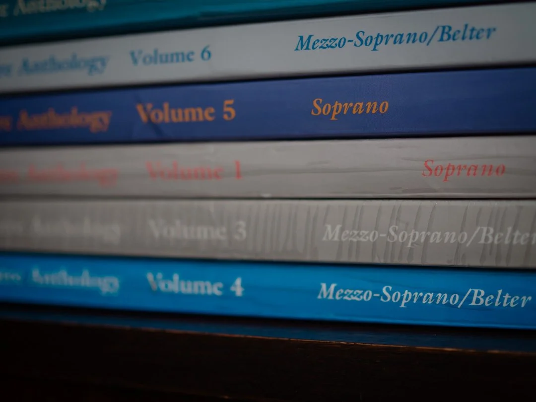 Stack of musical theatre song anthologies to support students choosing repertoire with musical theatre audition tips.