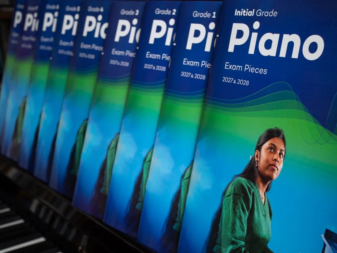 ABRSM Piano Exam Pieces books for the 2027-28 syllabus arranged across a piano keyboard