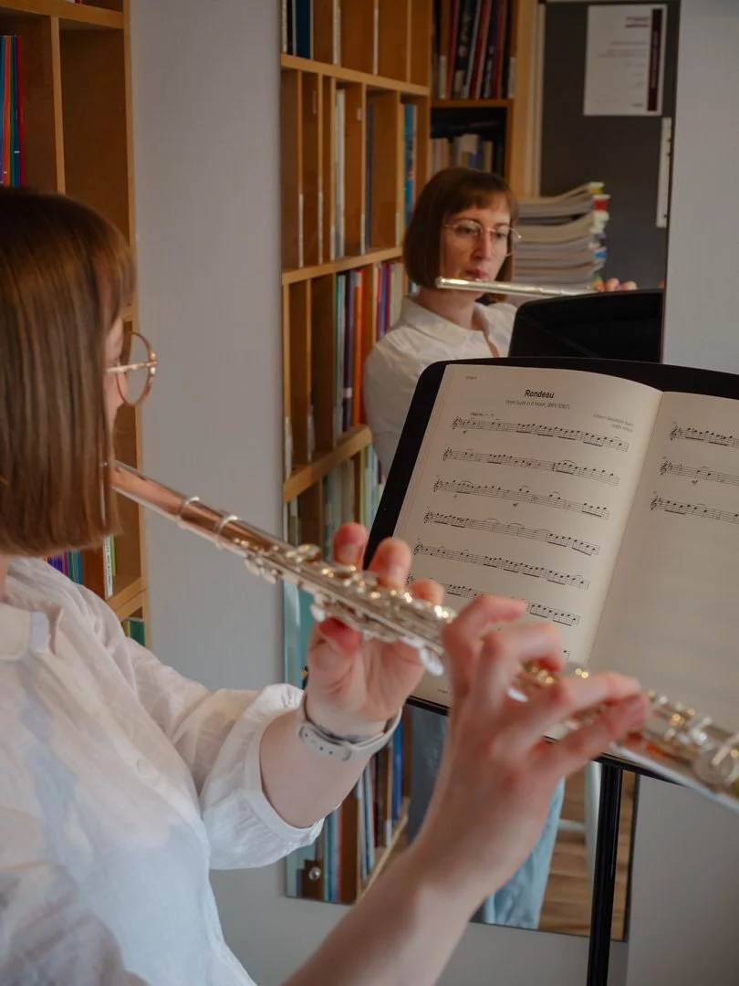 Adult flute student practising a piece, capturing the quiet focus of learning music as an adult