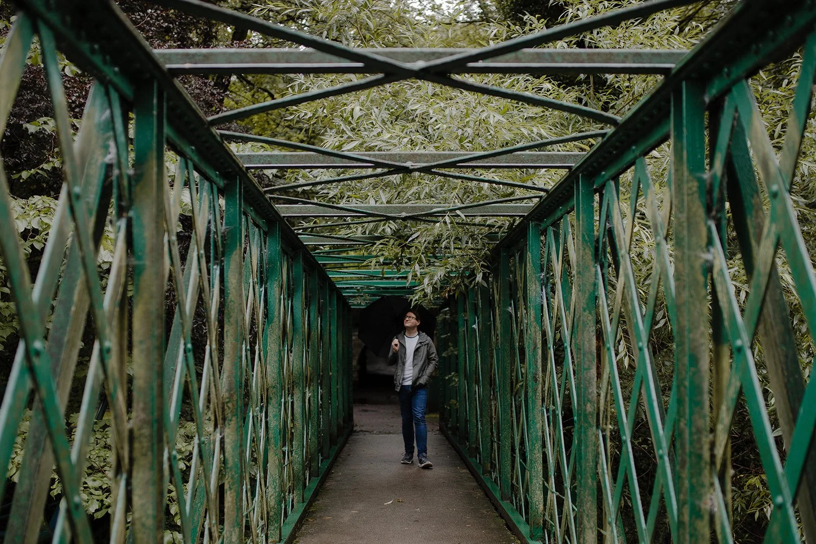 Private music teacher walking across a bridge over a river