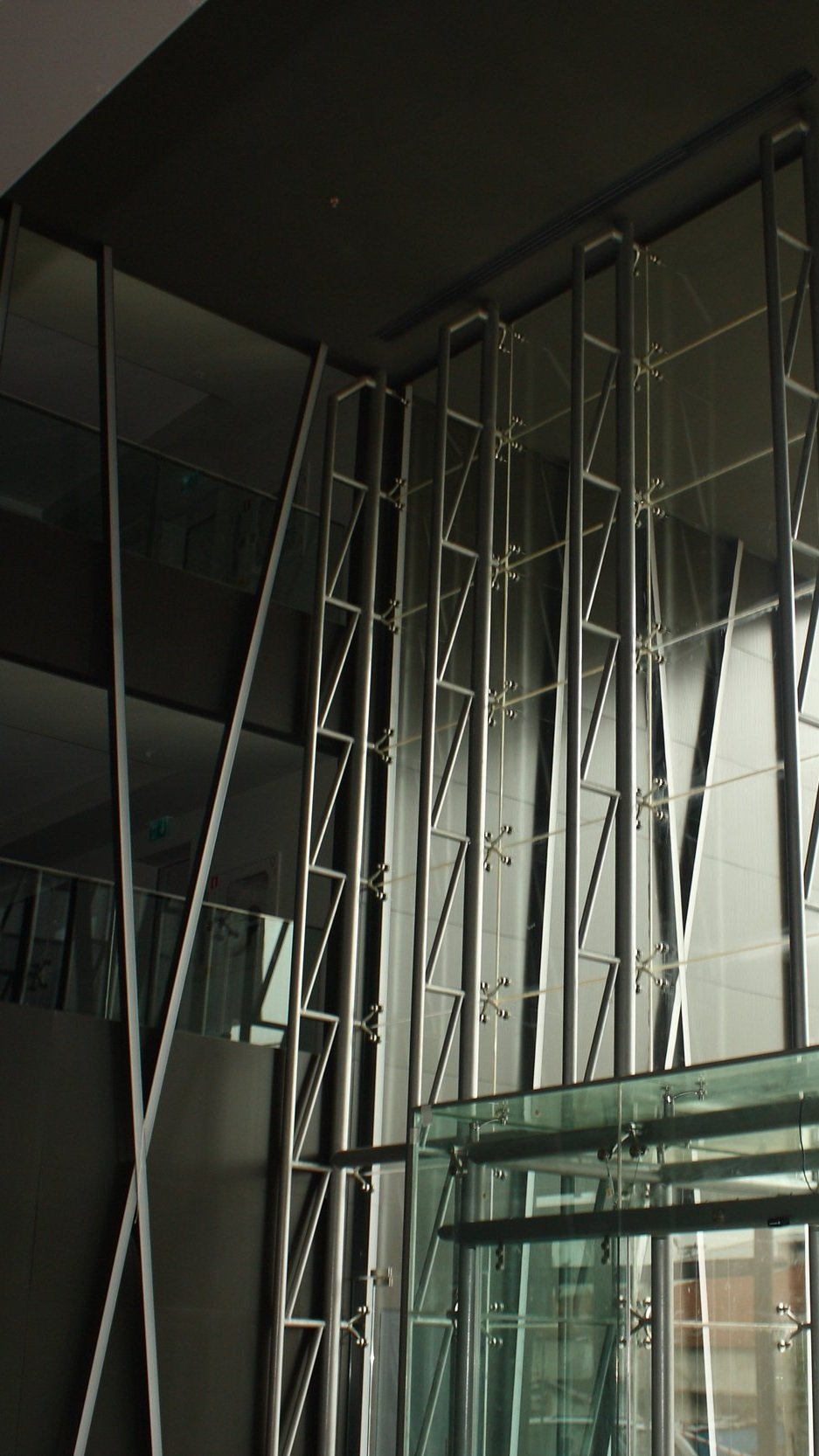 Modern building interior with glass walls and steel lattice structure.