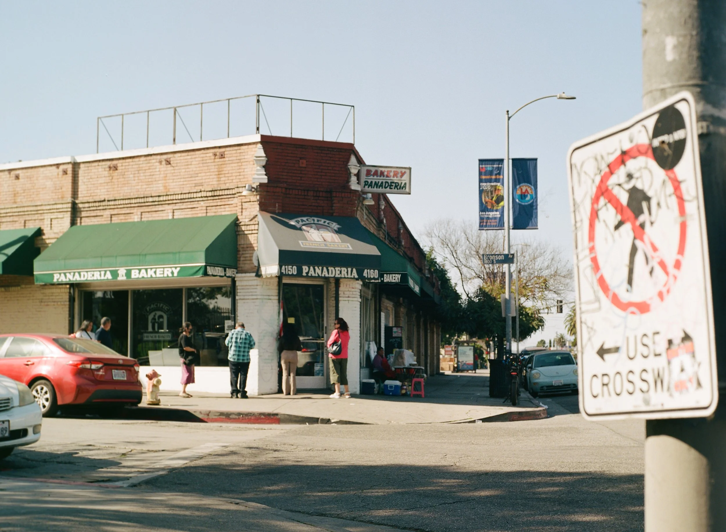  Landmarks , 2026, Medium format film, 16x20 inches
 
 
Lines snake out the door and around the corner in the early mornings, with everybody trying to take home a brown bag of pancito.