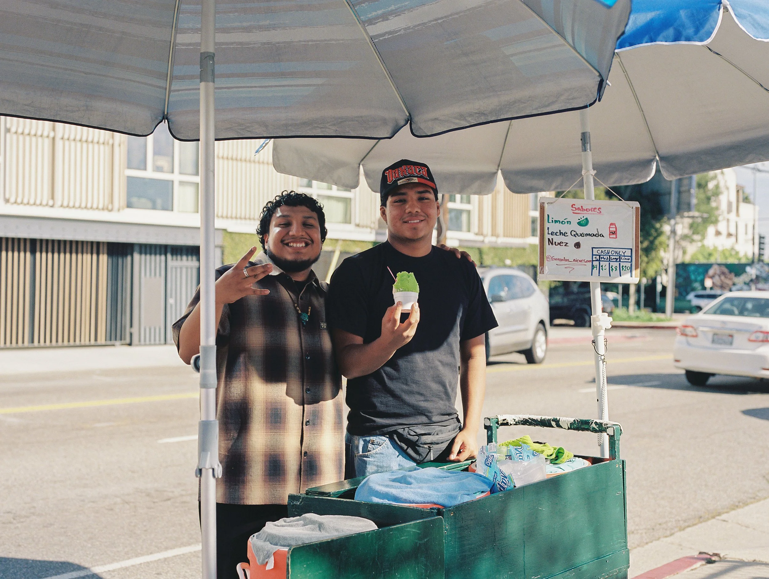  Nieves Gonzalos , 2026, Medium format film, 16x20 inches
 
 
After their grandfather’s passing, two brothers continue their tradition of making and selling nieves to the neighborhoods of Culver City and Mar Vista. For them, it’s more than just busin