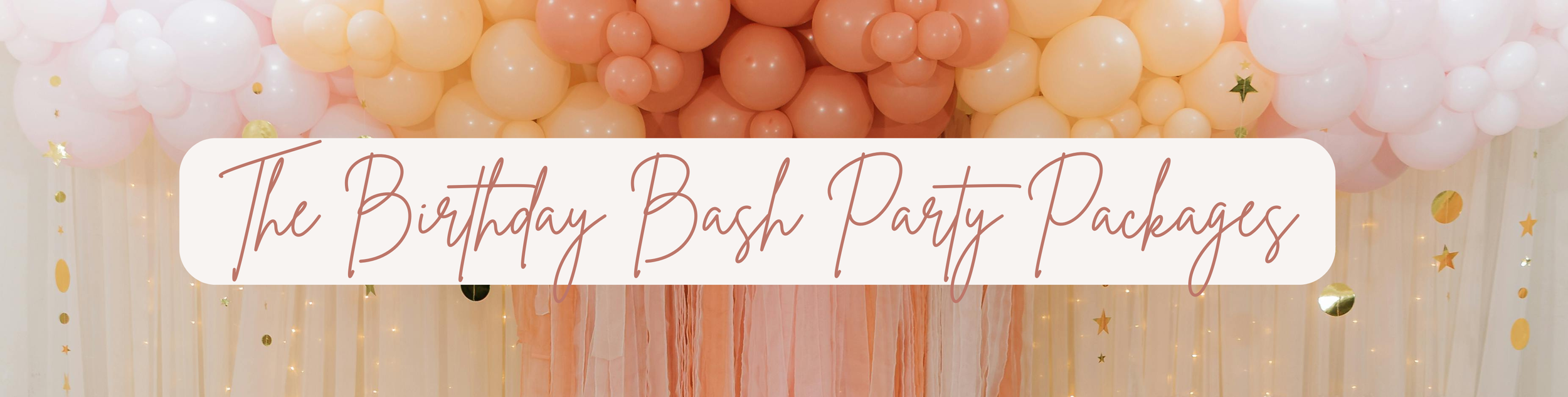 Blush, peach, and coral balloon garland over draped streamer backdrop with gold star and circle hanging accents