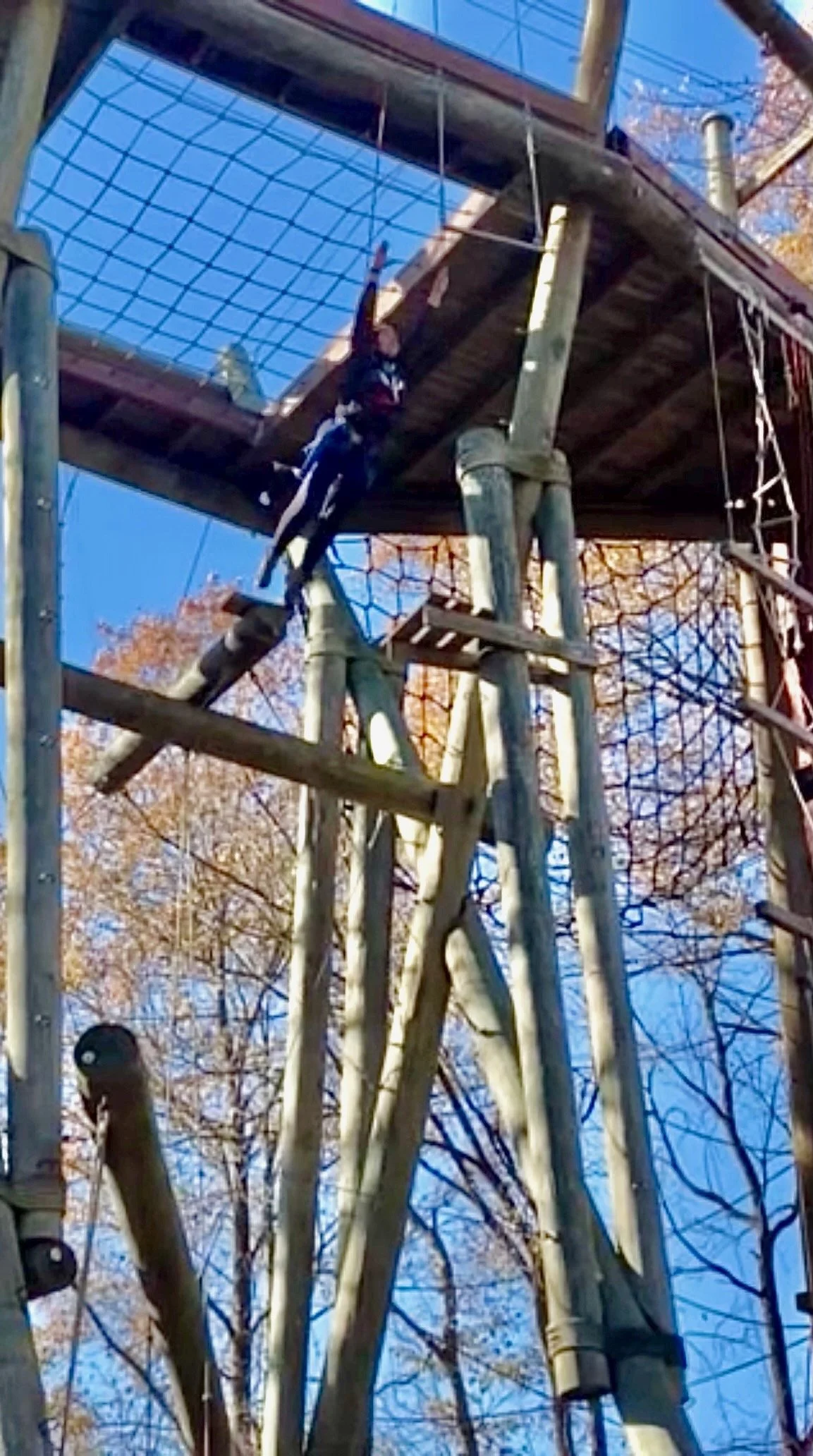 Joy jumping from a platform near the top of Camp Kern's Tango Tower while on belay