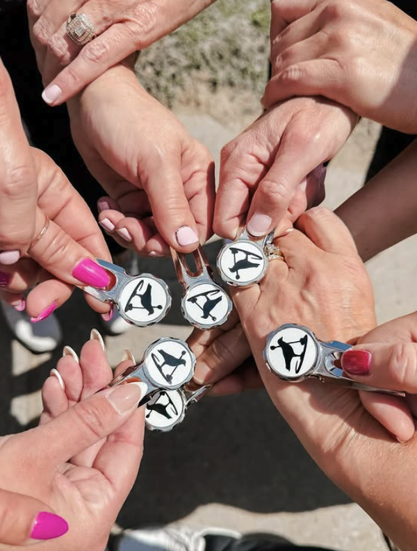 Multiple hands holding golf ball markers with images of athletes swinging golf clubs, arranged in a circle.