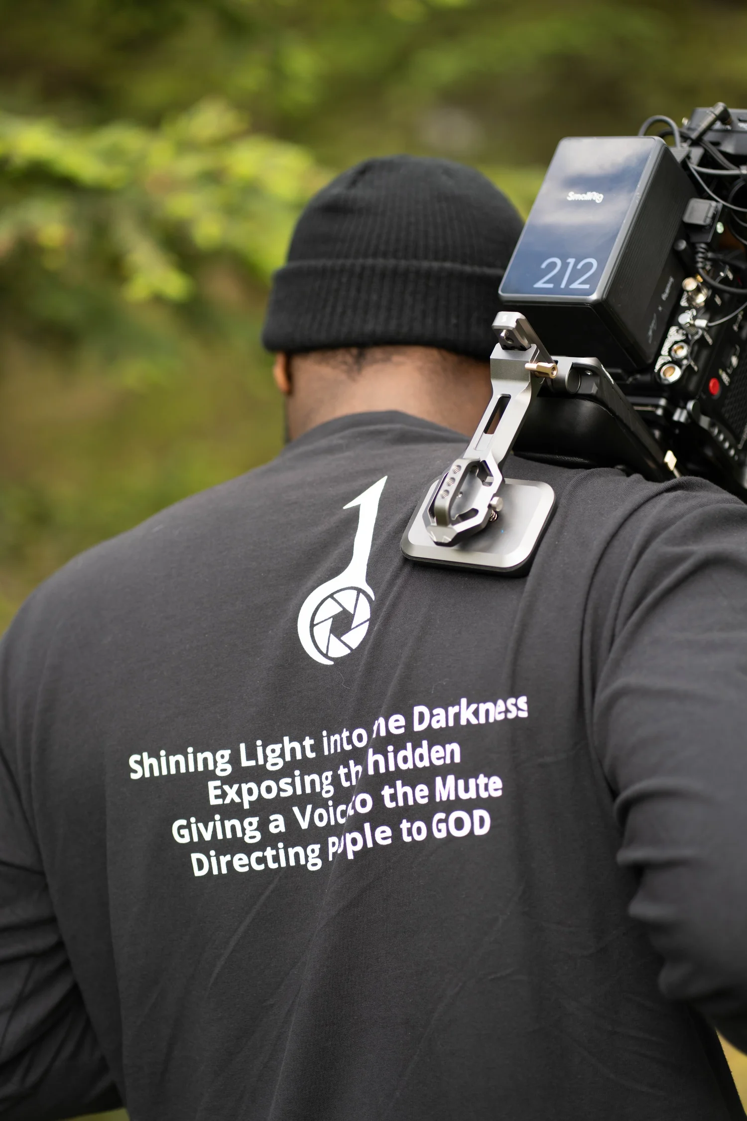 Dot One Media cinematographer carrying a camera rig on his shoulder in the Alaskan outdoors