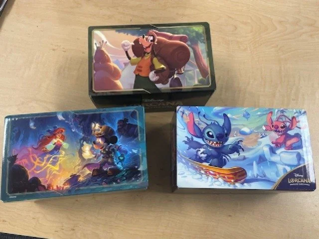 Free Lorcana Deck Box with $15 Lorcana purchase. Pick one up with your new Wilds Unknown boosters today!